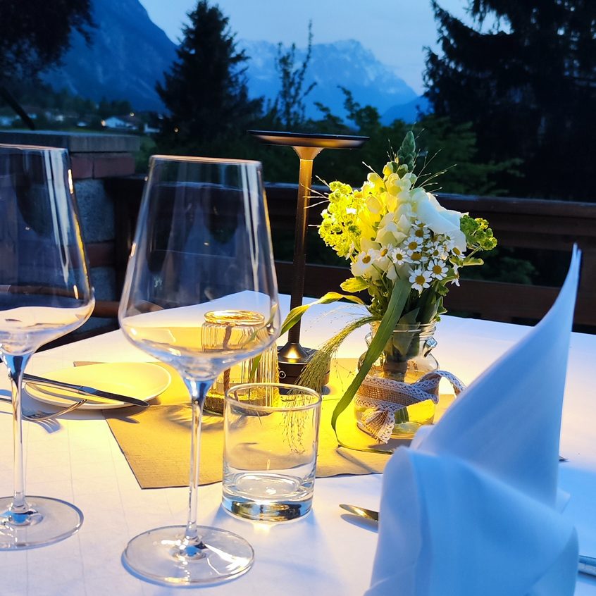 Elegant gedeckter Tisch mit Blumenarrangements in gemütlichem Restaurant.